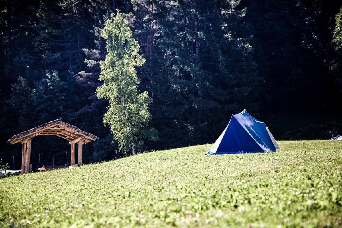 A 2-person tent pitched in a grassy field