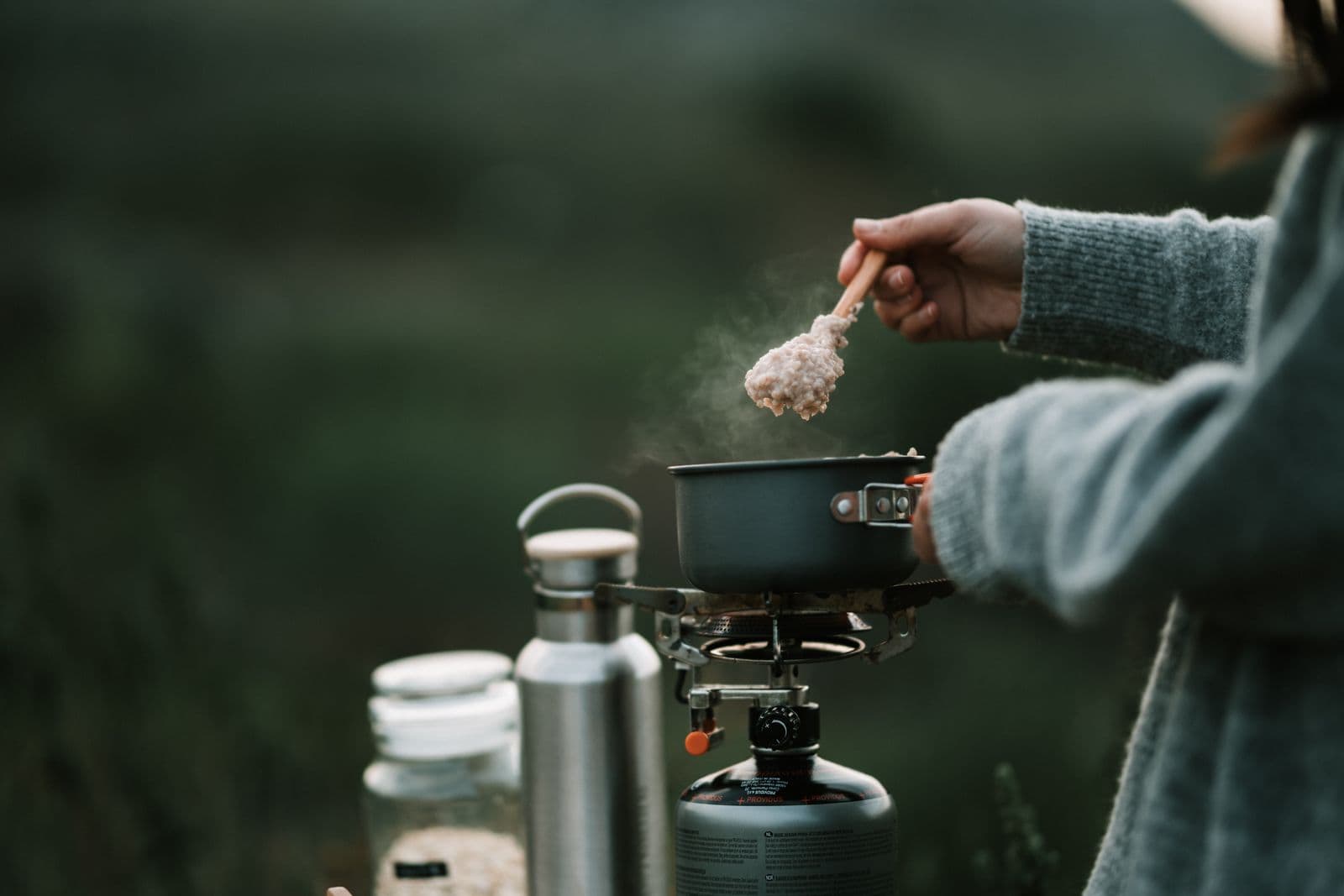 Food cooking in a pot on a portable stove at a campsite
