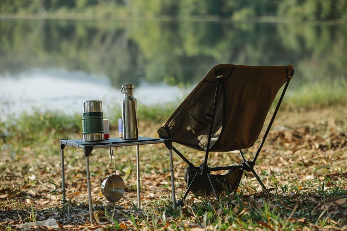 A peaceful lakeside campsite with a camp chair at dawn