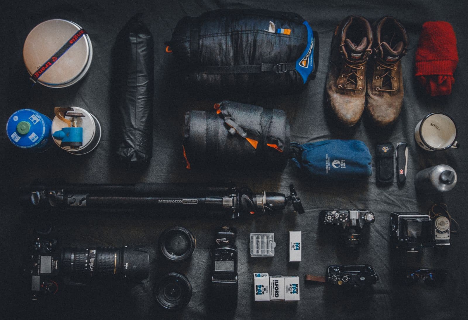 A flat lay of camping and photography equipment laid out neatly