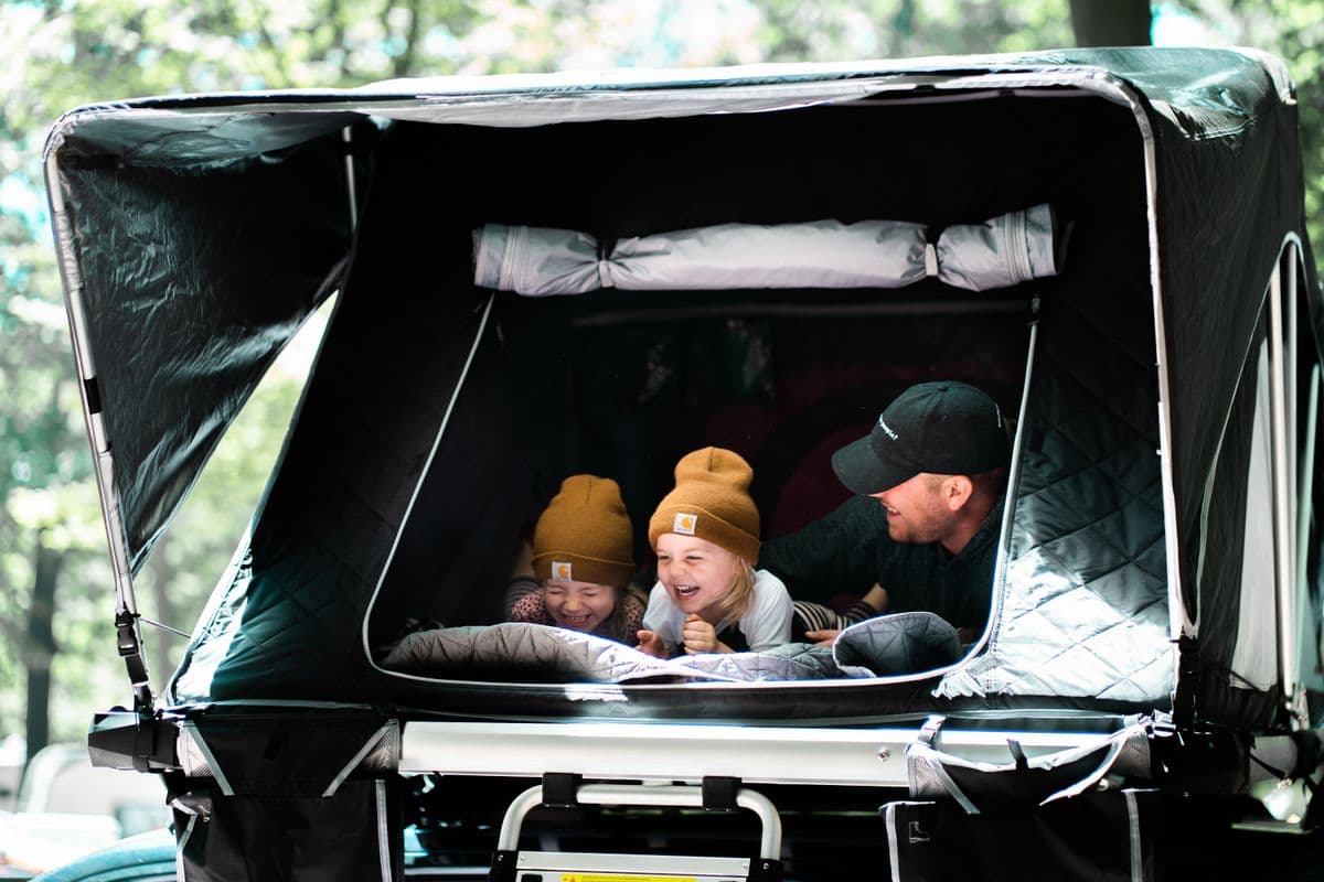 A father and children enjoying a family tent at a campsite